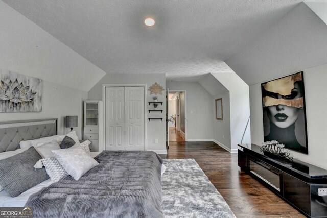 3085 Saint Andrews Dr, Duluth, GA 30096 - bedroom with wood finished floors, lofted ceiling, a closet, baseboards, and a textured ceiling