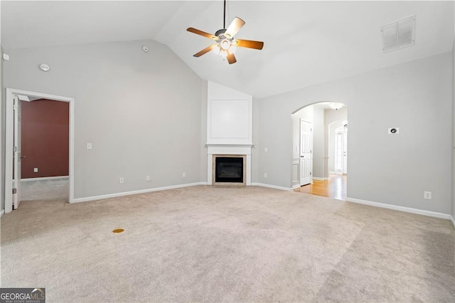 607 Little Shoals Ct, Canton, GA 30115 - unfurnished living room with ceiling fan, light colored carpet, lofted ceiling, arched walkways, and a glass covered fireplace