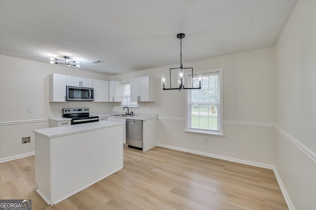 2011 Mims Rd, Hephzibah, GA 30815 - kitchen featuring stainless steel appliances, a chandelier, light wood-type flooring, light countertops, and white cabinets