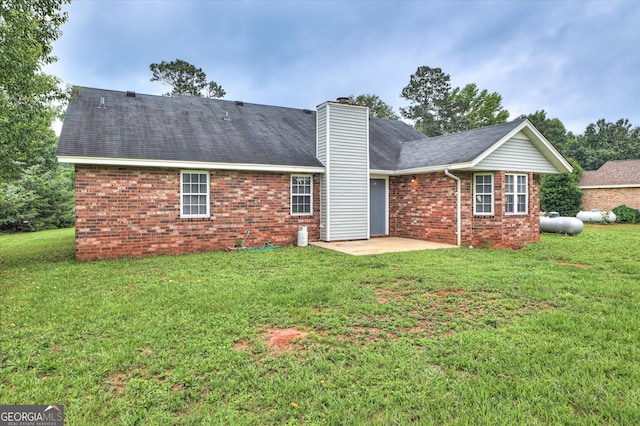 2011 Mims Rd, Hephzibah, GA 30815 - back of house featuring brick siding, a yard, a patio, and a chimney