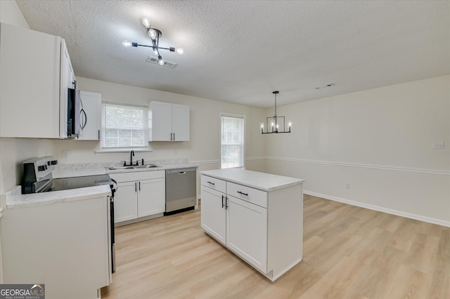 2011 Mims Rd, Hephzibah, GA 30815 - kitchen featuring stainless steel appliances, light wood-style flooring, a chandelier, healthy amount of natural light, and a textured ceiling