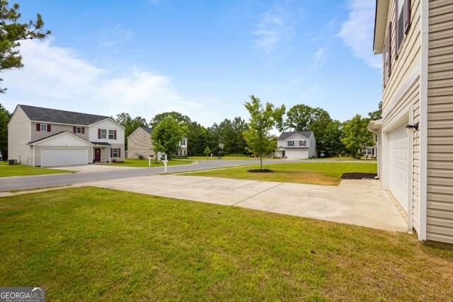 761 Riverside Dr NW, Calhoun, GA 30701 - view of green lawn featuring a residential view, driveway, and a garage