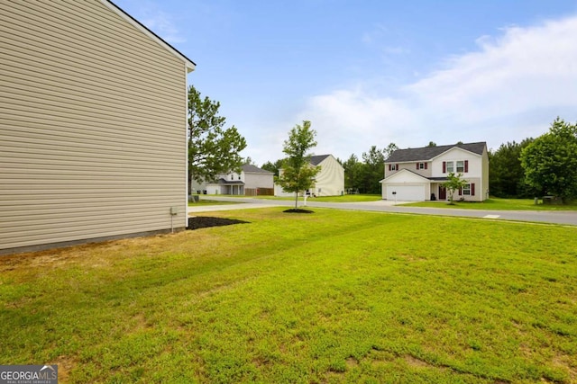 761 Riverside Dr NW, Calhoun, GA 30701 - view of grassy yard featuring asphalt driveway and a garage
