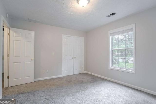 2140 Deer Trl, Suwanee, GA 30024 - unfurnished bedroom featuring carpet flooring, a closet, baseboards, and a textured ceiling