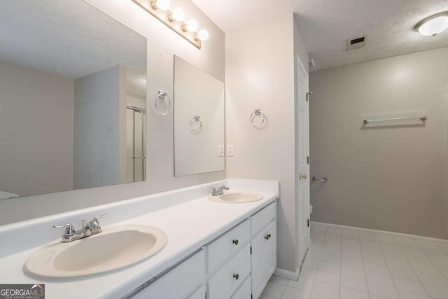2140 Deer Trl, Suwanee, GA 30024 - full bath with double vanity, a textured ceiling, toilet, tile patterned flooring, and baseboards