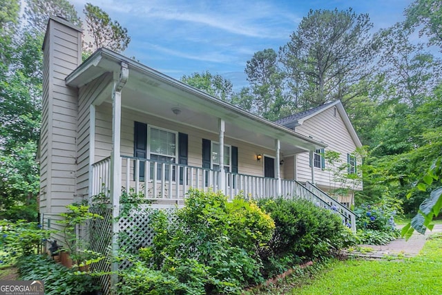 2140 Deer Trl, Suwanee, GA 30024 - view of front of house with a porch, a chimney, and stairway