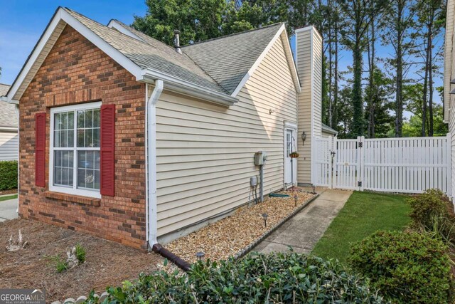 2657 Albion Farm Way, Duluth, GA 30097 - view of side of property with a gate, brick siding, a chimney, and roof with shingles