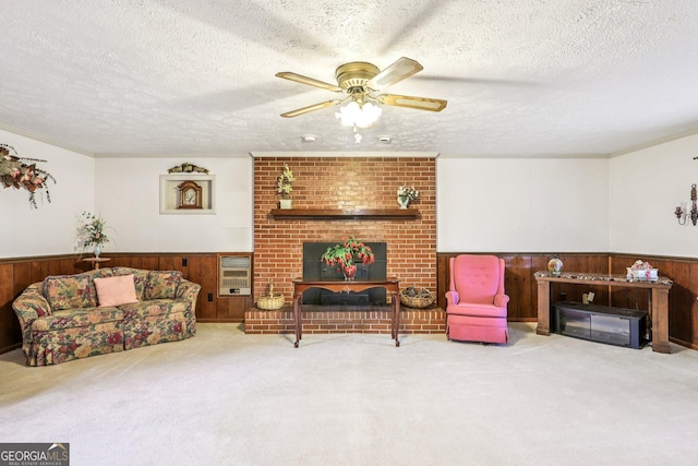 289 Hilton St, Monticello, GA 31064 - living area featuring a textured ceiling, wainscoting, a ceiling fan, carpet flooring, and wooden walls