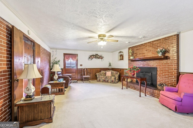 289 Hilton St, Monticello, GA 31064 - carpeted living area with a textured ceiling, a brick fireplace, a ceiling fan, a wainscoted wall, and wood walls
