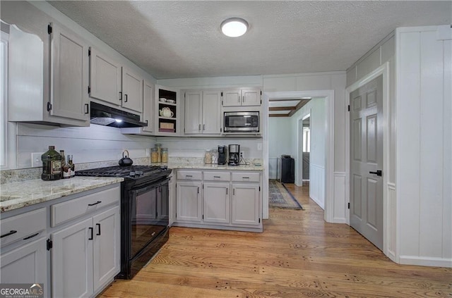 141 Holcomb Spur NW, Adairsville, GA 30103 - kitchen with black gas range, stainless steel microwave, under cabinet range hood, open shelves, and light wood-style floors
