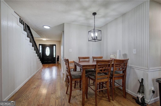 141 Holcomb Spur NW, Adairsville, GA 30103 - dining space featuring light wood-type flooring, a decorative wall, stairway, and a chandelier