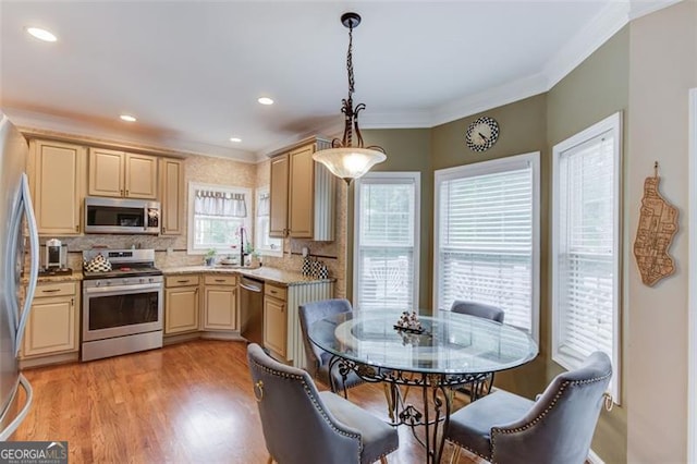 262 Sandhurst Ct, Suwanee, GA 30024 - kitchen featuring appliances with stainless steel finishes, crown molding, tasteful backsplash, light wood-style floors, and hanging light fixtures