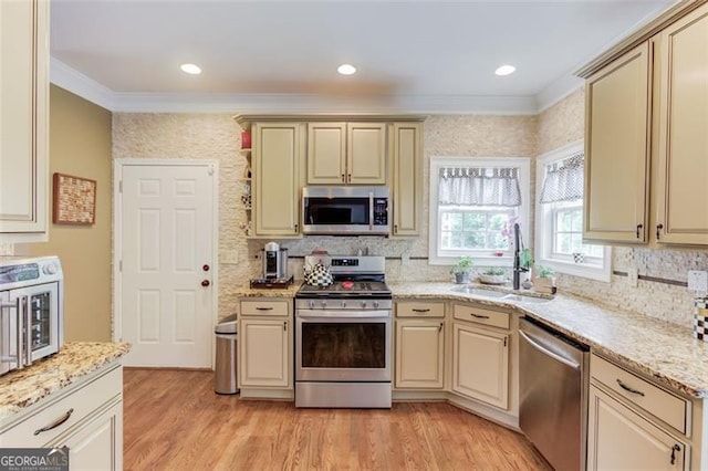 262 Sandhurst Ct, Suwanee, GA 30024 - kitchen featuring stainless steel appliances, a sink, cream cabinetry, ornamental molding, and backsplash