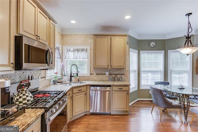 262 Sandhurst Ct, Suwanee, GA 30024 - kitchen featuring stainless steel appliances, cream cabinets, a sink, healthy amount of natural light, and crown molding