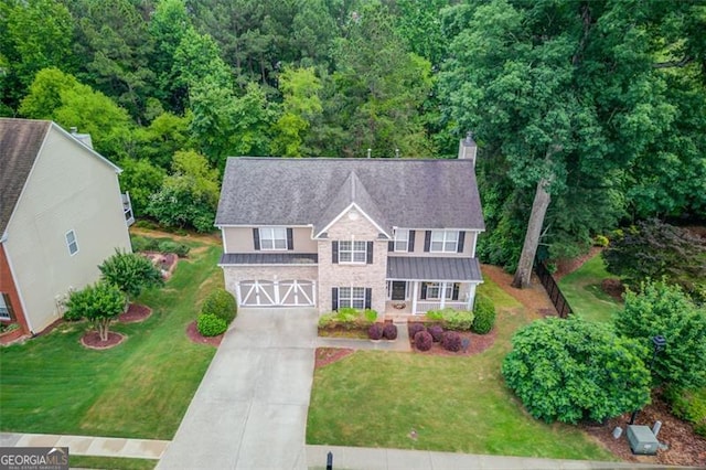 262 Sandhurst Ct, Suwanee, GA 30024 - traditional home featuring driveway, a garage, stone siding, a standing seam roof, and a front yard