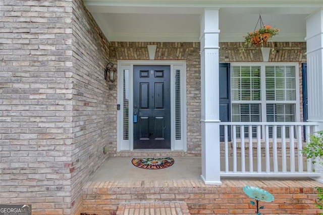262 Sandhurst Ct, Suwanee, GA 30024 - doorway to property featuring covered porch and brick siding