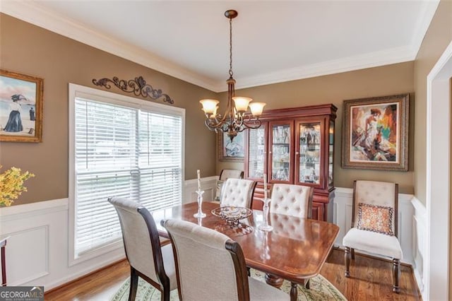 262 Sandhurst Ct, Suwanee, GA 30024 - dining space with a chandelier, wainscoting, light wood-style floors, ornamental molding, and a decorative wall