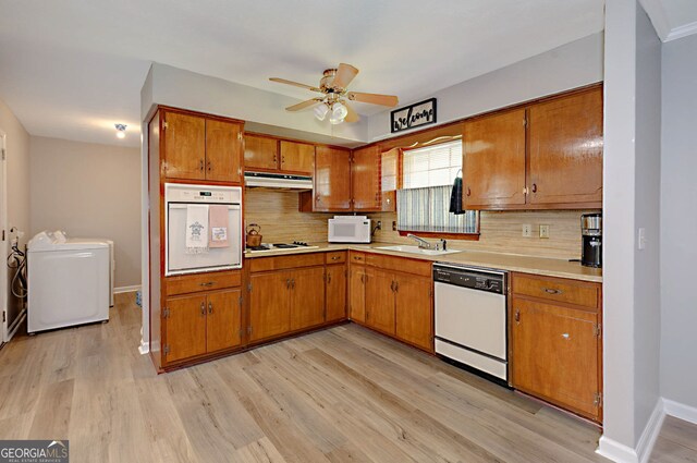 4814 Chesil Ave, Columbus, GA 31904 - kitchen featuring white appliances, washer and dryer, under cabinet range hood, and brown cabinets