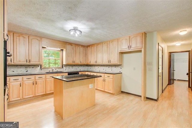 2612 Spring St, Dacula, GA 30019 - kitchen with light brown cabinetry, a sink, light wood-type flooring, tasteful backsplash, and a textured ceiling