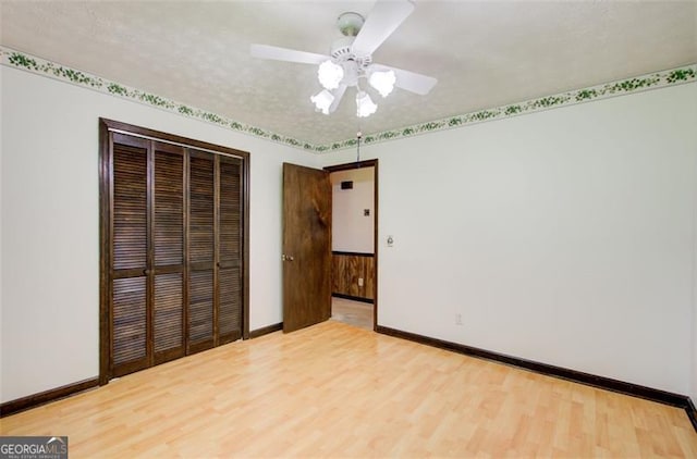2612 Spring St, Dacula, GA 30019 - unfurnished bedroom with a closet, wood finished floors, baseboards, and a ceiling fan