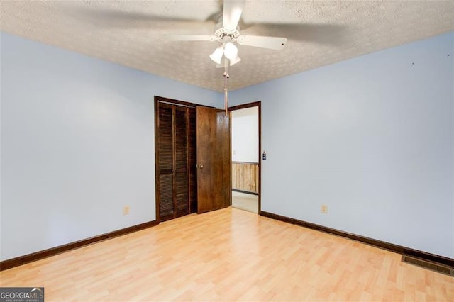 2612 Spring St, Dacula, GA 30019 - unfurnished bedroom featuring wood finished floors, a closet, a textured ceiling, and baseboards
