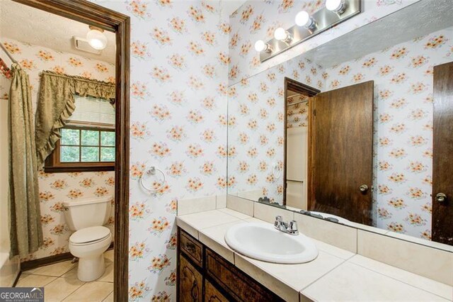 2612 Spring St, Dacula, GA 30019 - bathroom with vanity, tile patterned floors, toilet, wallpapered walls, and baseboards
