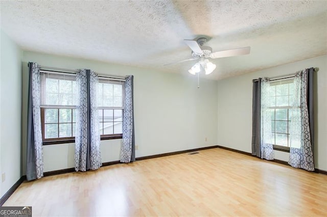 2612 Spring St, Dacula, GA 30019 - empty room with wood finished floors, plenty of natural light, a textured ceiling, and a ceiling fan