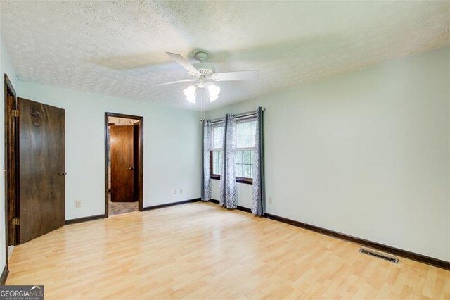 2612 Spring St, Dacula, GA 30019 - unfurnished bedroom with light wood-style floors, baseboards, a textured ceiling, and ceiling fan