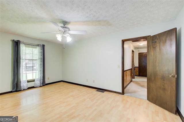 2612 Spring St, Dacula, GA 30019 - unfurnished room featuring light wood-style floors, attic access, a textured ceiling, ceiling fan, and baseboards