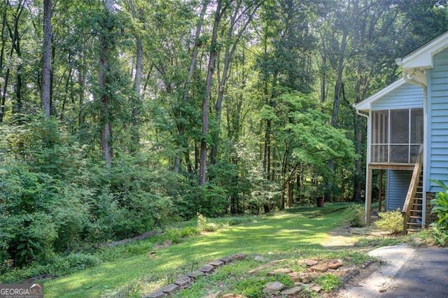2612 Spring St, Dacula, GA 30019 - view of green lawn with stairway, a sunroom, and a view of trees