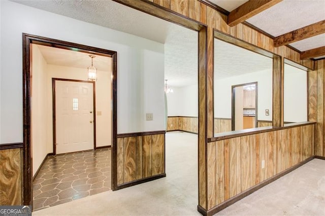2612 Spring St, Dacula, GA 30019 - corridor featuring wood walls, a wainscoted wall, beam ceiling, light flooring, and a textured ceiling