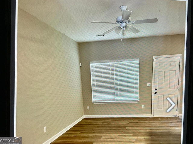 5057 Windsor Forrest Ln, Atlanta, GA 30349 - unfurnished room with wood finished floors, ceiling fan, and wallpapered walls