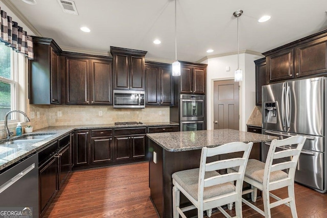2525 Well Springs Dr, Buford, GA 30519 - kitchen featuring stainless steel appliances, dark stone counters, dark wood-type flooring, a center island, and dark brown cabinetry