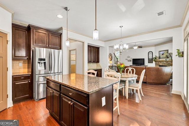 2525 Well Springs Dr, Buford, GA 30519 - kitchen featuring stainless steel fridge, a breakfast bar area, wood finished floors, tasteful backsplash, and a kitchen island