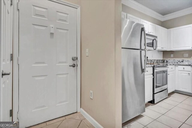 1850 Cotillion Dr Unit 3305, Dunwoody, GA 30338 - kitchen with appliances with stainless steel finishes, light tile patterned floors, white cabinets, and ornamental molding