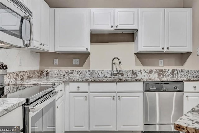 1850 Cotillion Dr Unit 3305, Dunwoody, GA 30338 - kitchen with stainless steel appliances, a sink, white cabinets, backsplash, and light stone counters