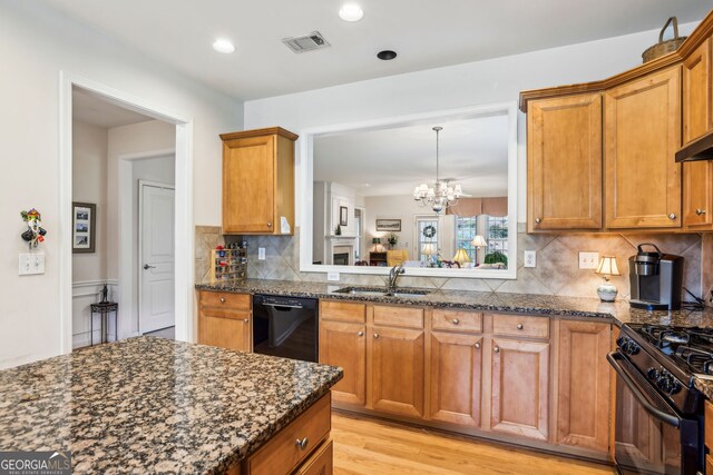 5105 Kings Common Way, Cumming, GA 30040 - kitchen with a sink, black appliances, brown cabinets, dark stone counters, and recessed lighting