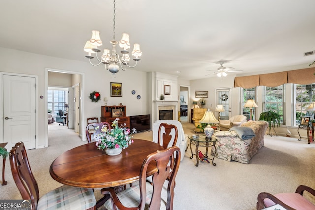 5105 Kings Common Way, Cumming, GA 30040 - dining area featuring light carpet, a chandelier, ceiling fan, and a glass covered fireplace