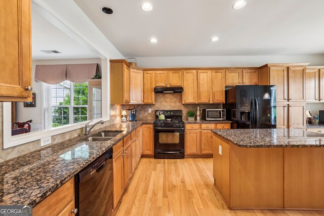 5105 Kings Common Way, Cumming, GA 30040 - kitchen featuring black appliances, under cabinet range hood, a sink, light wood finished floors, and backsplash