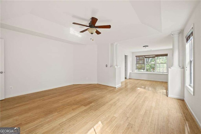 2890 Winterhaven Ct, Atlanta, GA 30360 - spare room featuring ornate columns, light wood finished floors, a tray ceiling, a ceiling fan, and baseboards