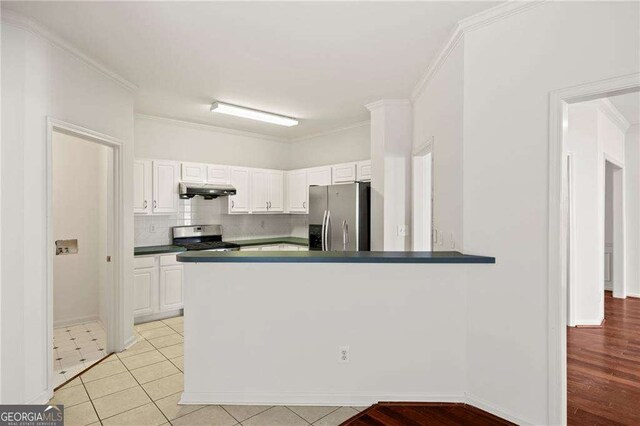2890 Winterhaven Ct, Atlanta, GA 30360 - kitchen featuring stainless steel fridge, stove, under cabinet range hood, white cabinetry, and dark countertops