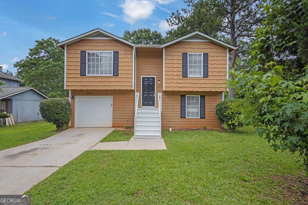 5653 Bradley Cir, Lithonia, GA 30038 - bi-level home featuring driveway, a front yard, and a garage