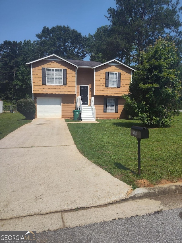 5653 Bradley Cir, Lithonia, GA 30038 - bi-level home featuring driveway, a front yard, and a garage