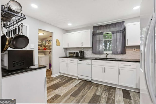 2860 Jefferson St, Austell, GA 30106 - kitchen with white appliances, washer and clothes dryer, dark countertops, wood finished floors, and white cabinets