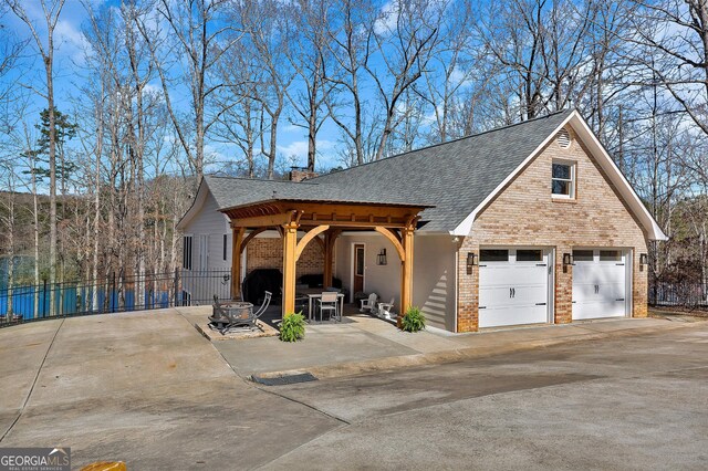 201 Hickory Hill Ln, Martin, GA 30557 - view of front of property featuring brick siding, driveway, a garage, a shingled roof, and a patio