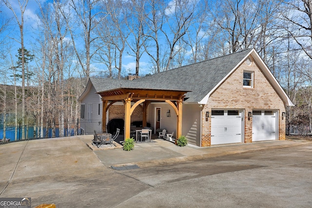 201 Hickory Hill Ln, Martin, GA 30557 - view of front of home with brick siding, driveway, a garage, a shingled roof, and a patio