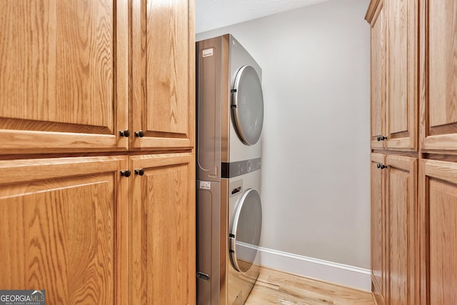 201 Hickory Hill Ln, Martin, GA 30557 - washroom with cabinet space, stacked washer and clothes dryer, and light wood-style flooring