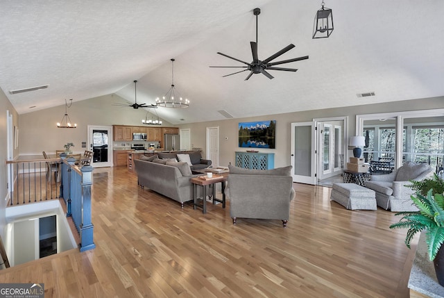 201 Hickory Hill Ln, Martin, GA 30557 - living room featuring a ceiling fan, a chandelier, light wood finished floors, high vaulted ceiling, and a textured ceiling