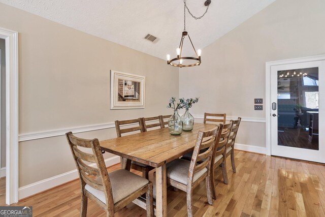 201 Hickory Hill Ln, Martin, GA 30557 - dining room featuring a chandelier, light wood-type flooring, lofted ceiling, and baseboards
