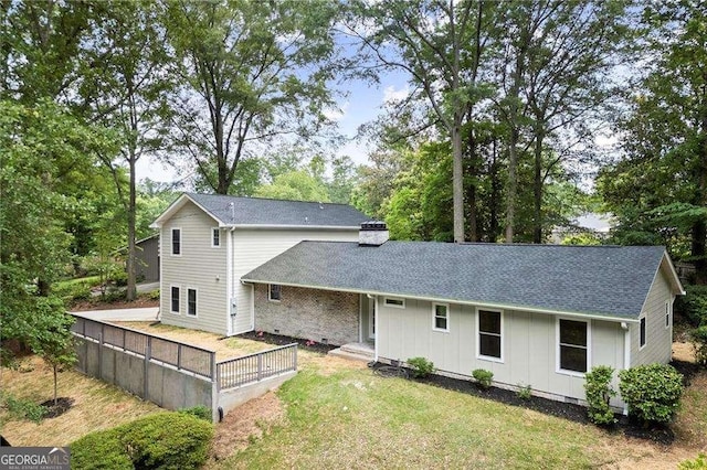 6405 Cherry Tree Ln, Atlanta, GA 30328 - rear view of house featuring board and batten siding, a shingled roof, and a yard